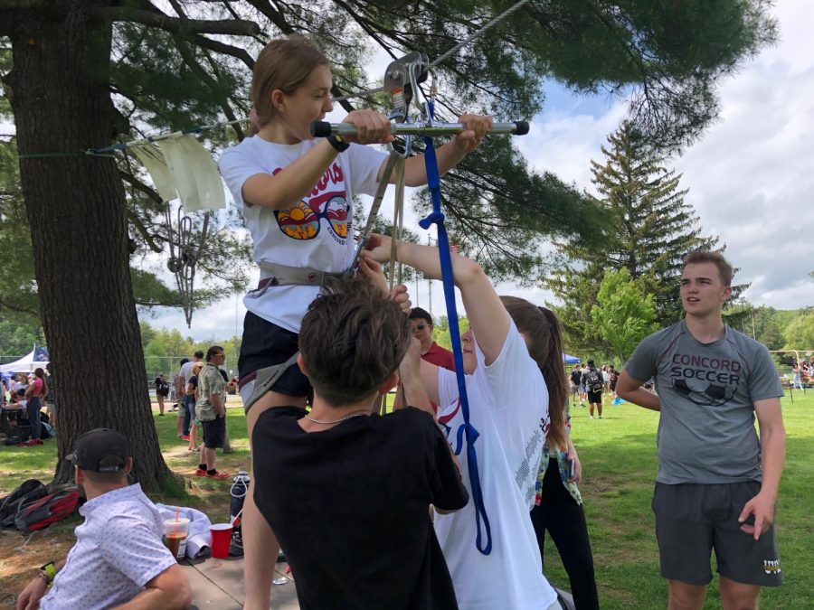 Senior Sarah West prepares for a zip line ride compliments of ROPE students and staff. Hooking her up are junior Cam Pacheco and senior Kaleigh Baker as junior Cam Littlefield supervises.