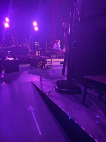 A view from the wings of the stage in the auditorium shows students preparing for their upcoming production of The Laramie Project.