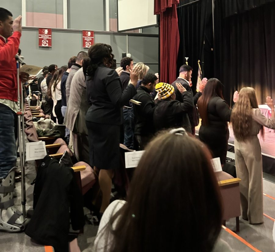 New Amercians take the oath of citizenship during a March 16 naturalization ceremony at Concord High School.